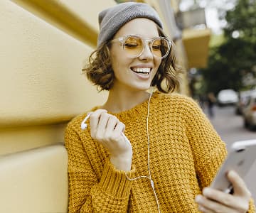 young women dressed in all yellow fit listening to online course and laughing